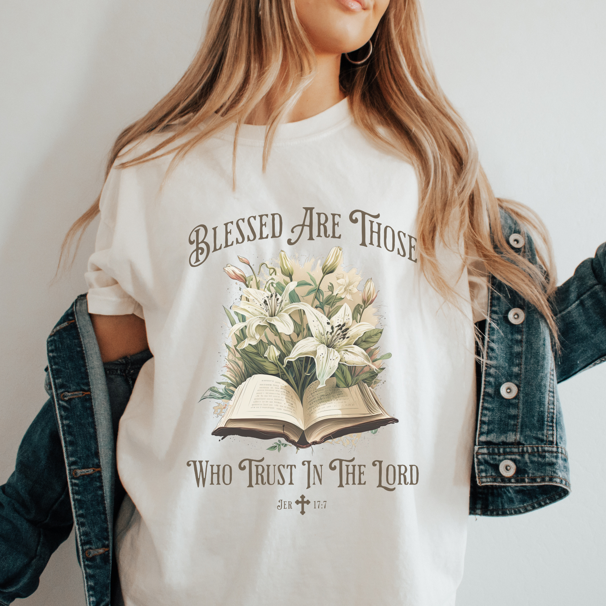 woman standing wearing a natural color crewneck short sleeve womens christian t shirt that has a design of an open bible and flowers that says blessed are those who trust in the lord