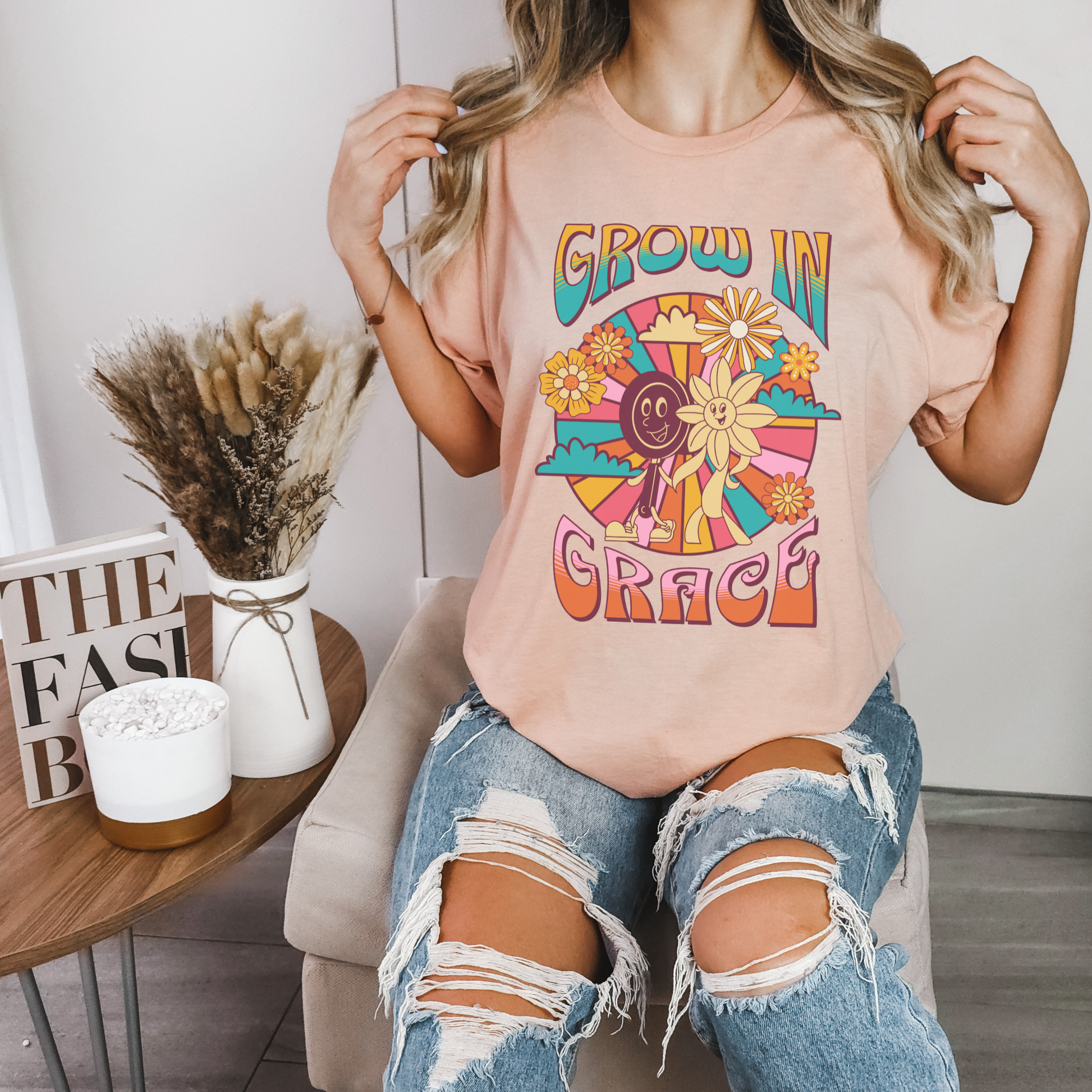 woman sitting in a chair wearing a short sleeve crewneck boho christian shirt that says grow in grace