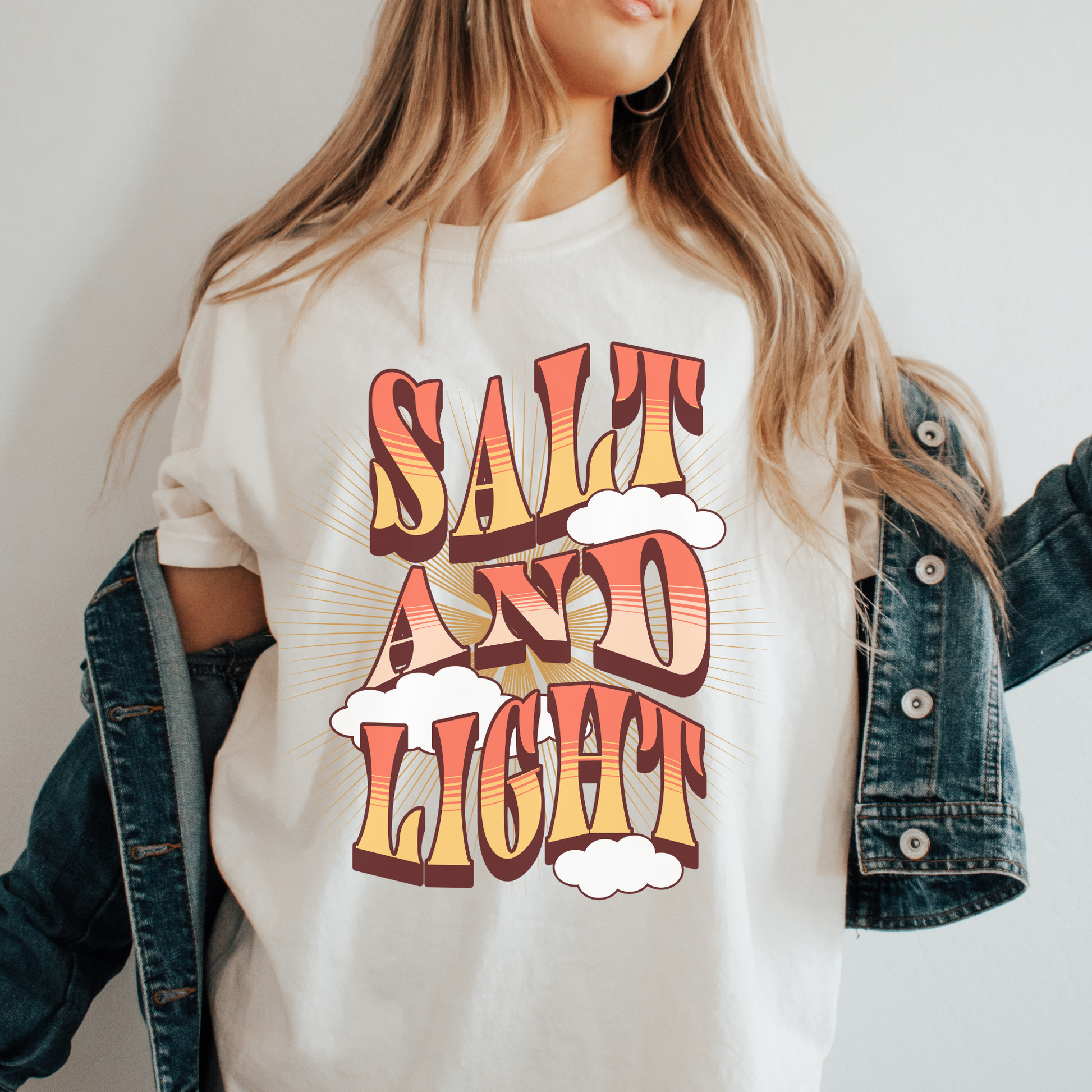 woman wearing a bible verse shirt that says salt and light in a boho style font design