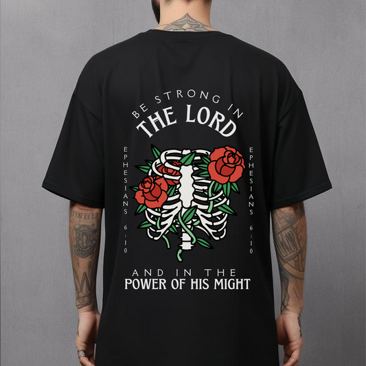 back design of a mens christian streetwear bible verse shirt that is black with short sleeves in a traditional tattoo style design that says be strong in the lord and the power of his might