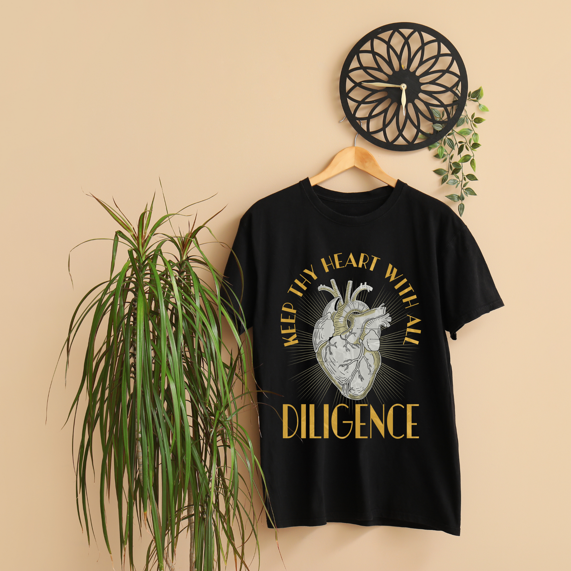 a black crewneck short sleeve christian t shirt with bible verse that says keep thy heart with all diligence hanging on a hanger 