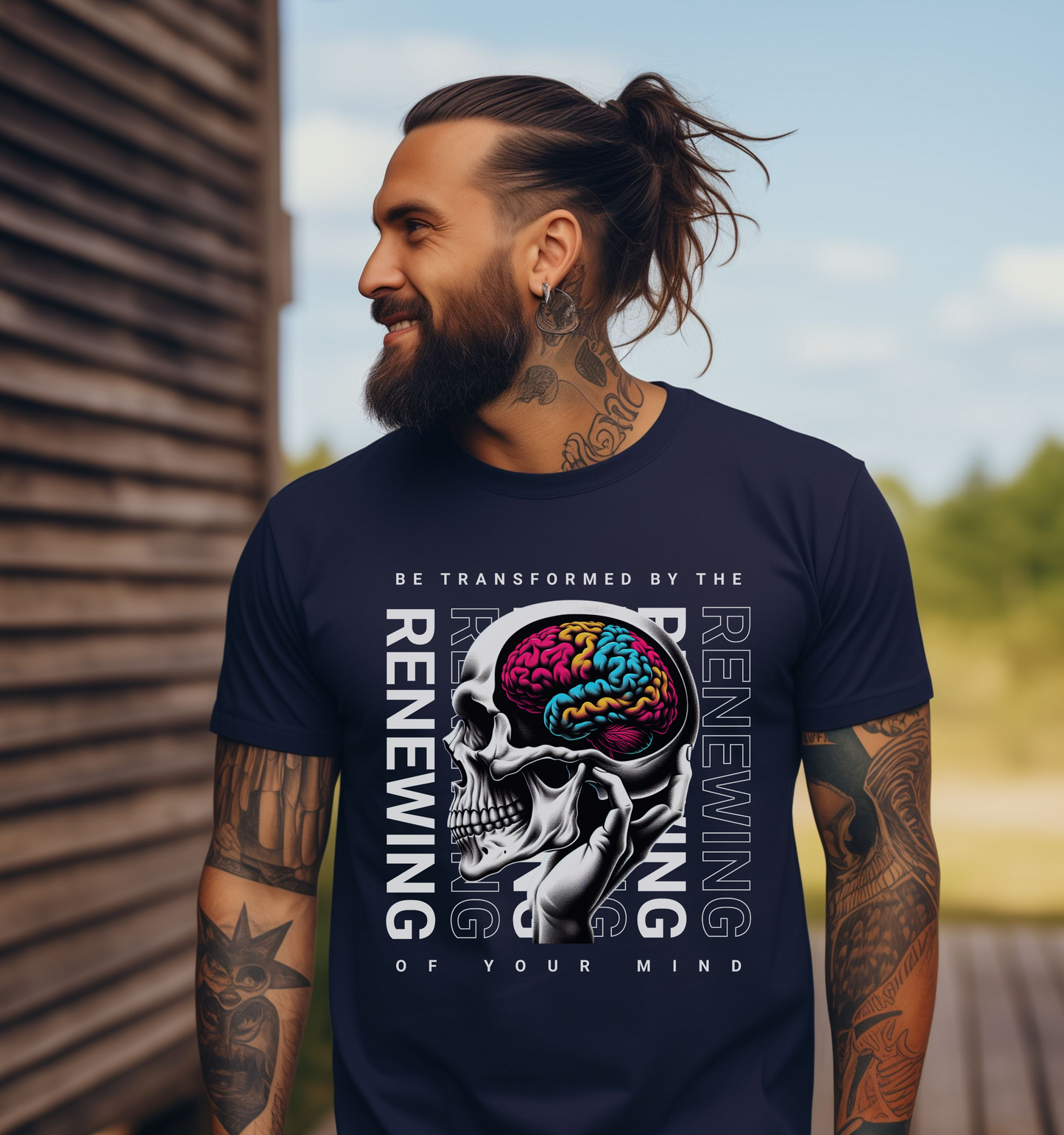 man wearing a navy crewneck short sleeve christian religious graphic tee that says be transformed by the renewing of your mind