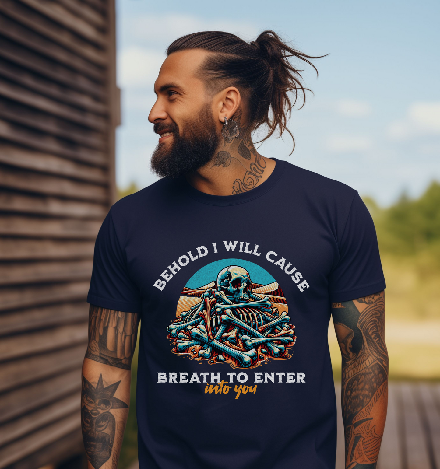 man wearing a navy short sleeve crewneck mens christian streetwear graphic t shirt that has the image of a pile of skeleton bones in the desert that says behold i will cause breath to enter into you ezekiel 37:5 bible verse